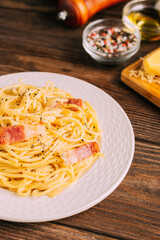 Classic italian pasta carbonara on white plate wooden tabletop, rustic style, Top view copy space