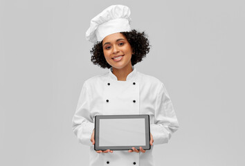 cooking, culinary and people concept - happy smiling female chef in toque and jacket with tablet pc computer over grey background