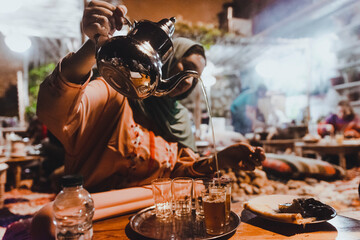 Fototapeta na wymiar Moroccan woman nigh serving tea during Ramadan. Night life