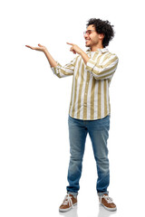 people and fashion concept - happy smiling man in glasses holding and showing something imaginary on his hand over white background