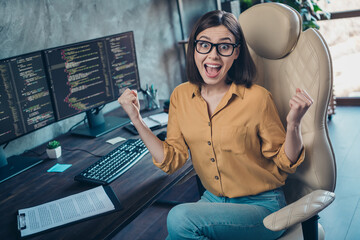 Portrait of attractive ecstatic cheerful lucky girl having fun developing web project startup at...