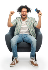 technology, people and leisure concept - happy smiling young man in headphones with gamepad playing...