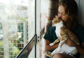 Portrait of teen girl with cat at home - 516749914