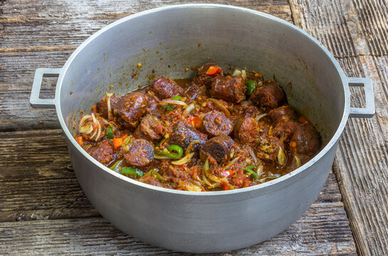 Rougail de saucisses fum&eacute;es dans une marmite cr&eacute;ole r&eacute;unionnaise 