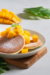 Delicious Japanese souffle pancake with dice mango and jam on white table background.
