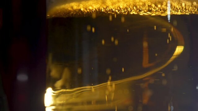 Side view of beer bubbles rising to the top of the glass.
