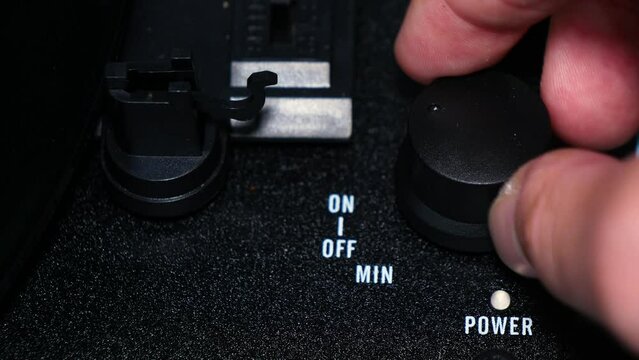 Turning the power on to a record player.
