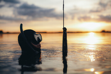 Male diver holding a speargun in sea water