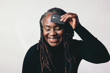 Cheerful mature woman smiling while holding a credit card