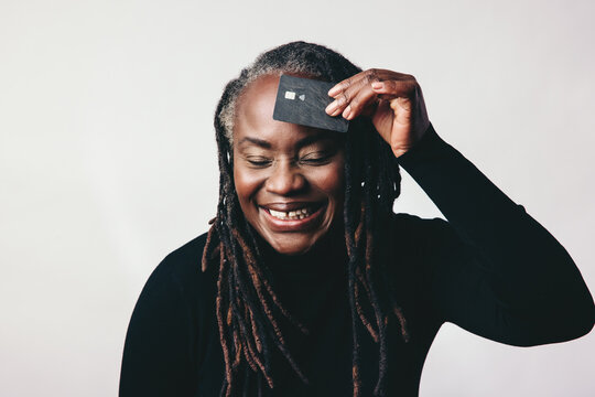 Cheerful Mature Woman Smiling While Holding A Credit Card