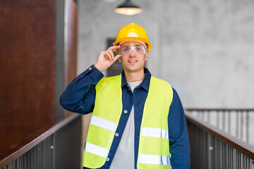architecture, construction business and building concept - happy smiling male architect in helmet, goggles and safety west at office