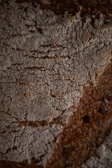 Fresh baked homemade organic bread close-up on a wooden background.