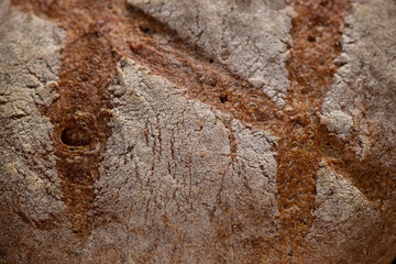 Fresh baked homemade organic bread close-up on a wooden background.