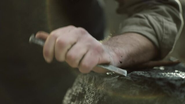 Sculptor shaping a big stone. Rock breaking. Stone carving. Changing tools.
