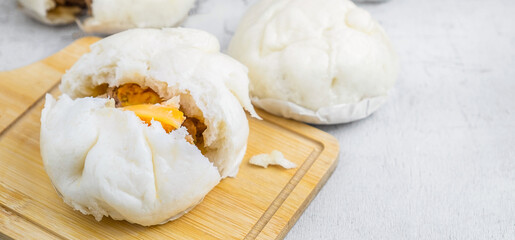 The Chinese  food menu of Steamed Buns split in the middle reveals Pork Belly on white table