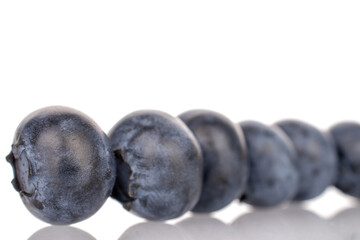 Several berries of organic ripe blueberries, close-up, on a white background.