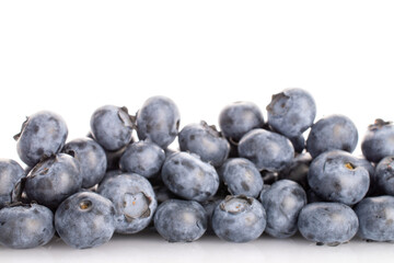 Several berries of organic ripe blueberries, close-up, on a white background.