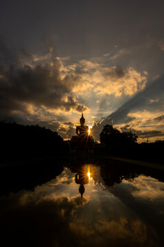 Vertical silhouette  Big Golden Buddha statue sunset sky in Thailand temple,khueang nai District, Ubon Ratchathani province, Thailand.Amazing Buddha image with sunny sky clouds.