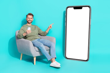 Full length photo of young guy hold telephone index promo wear shirt jeans sneakers isolated on...