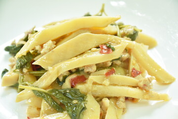 spicy stir fried bamboo shoot and chop pork with basil leaf on plate