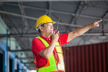 Warehouse worker working in factory warehouse industry and using radio talking communication, Foreman in hardhat safety vest with Two-Way radio working in logistics center