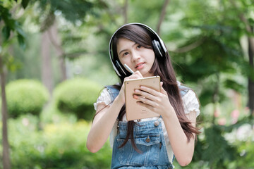 Young Asian teenage girl with tablet and notebook