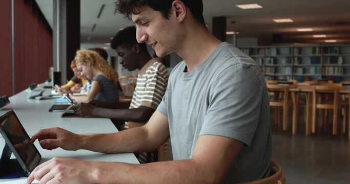 Multiracial young students learing together inside school library