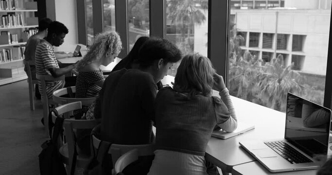 Multiethnic group of young students learing together inside school library - Black and white editing
