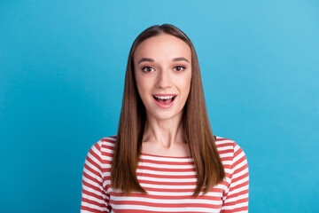 Surprised happy beautiful woman looking in camera with excitement. Isolated on blue color background