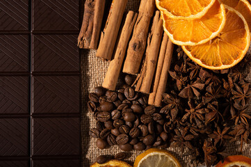 Citrus fruit, cinnamon, star anise, coffee beans and dark chocolate up close from above
