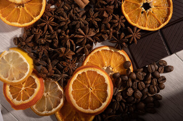 Citrus fruit, cinnamon, star anise, coffee beans and dark chocolate up close from above