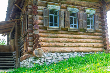 Large diameter logs and windows in a rustic log house built in the 19th century. Dark log walls of...