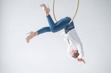 Naklejka premium Caucasian woman in casual clothes on an aerial hoop. 