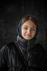 Portrait of a young beautiful fair-haired girl in a dark autumn jacket.