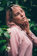Beautiful girl under the summer rain in the park