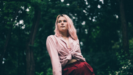 Beautiful girl under the summer rain in the park