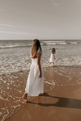 Mother walking after child near sea