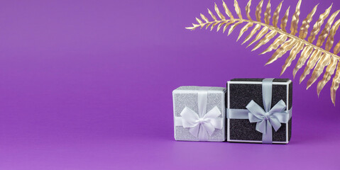 Large and small gift boxes on a purple background with a golden palm leaf.