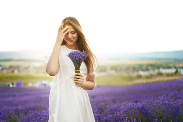 Portrait of a young attractive woman in a lavender field at sunset