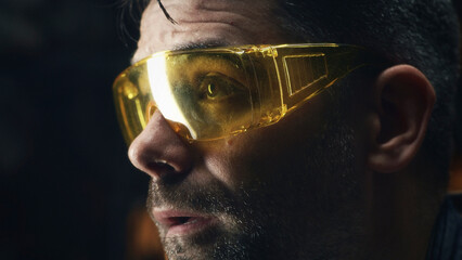 Exhausted worker in protective goggles and gloves after processing metal products for his small...