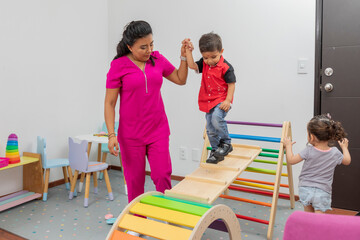 Pediatric doctor giving therapy to a child in the playground of her medical office