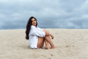 Fototapeta na wymiar Girl in the dunes on a cloudy day