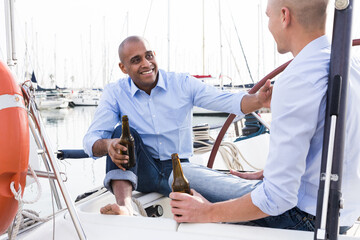A couple of guys in blue shirts and jeans chatting on a private yacht in the port