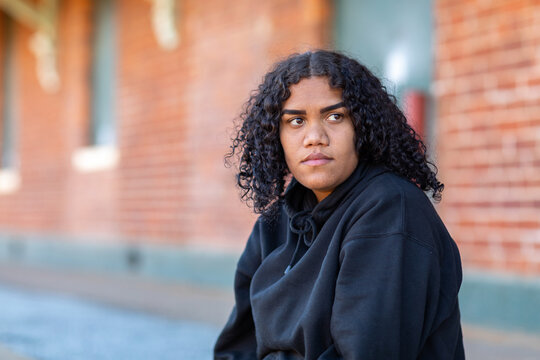 one teenager sitting by herself and glancing away