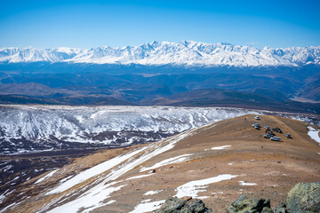 View from a repeater on snowy tops of Altai mountains. Cars on top of mountain near Aktash town,...