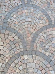 Mosaico romano antiguo lleno de piedras, componiendo formas circulares o semicirculares