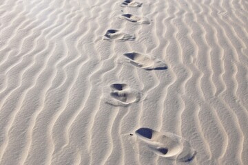 Adult person footprints in the desert dunes. Ripples in the sand made by the wind