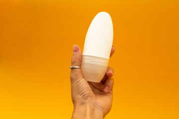 A girl is holding a deodorant in a white package
