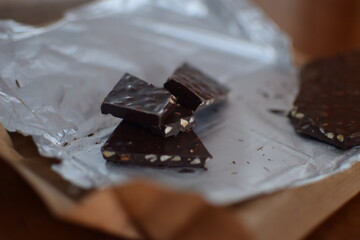 Dark chocolate with nuts on a paper wrap