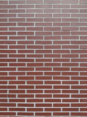 Fototapeta premium Background de pared de ladrillos rojos todos iguales, pura simetría y estructura arquitectónica rojiza